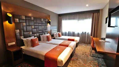a hotel room with two beds and a desk at XO Hotels Park West in Amsterdam
