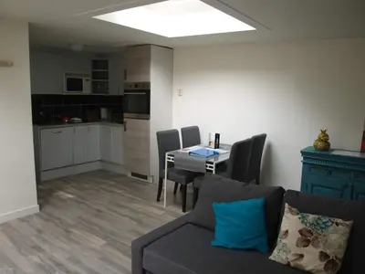 a living room with a couch and a table with chairs at JaBaKi Garden House in Hoofddorp