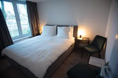 a bedroom with a bed and a chair and a window at B&B Gabriela Amsterdam in Amsterdam