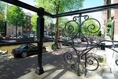 a balcony with a car parked on a city street at 1637: Historic Canal View Suites in Amsterdam