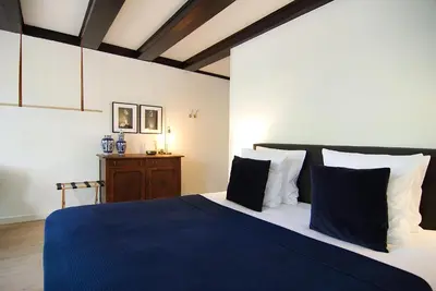 a bedroom with a bed with blue and white pillows at 1637: Historic Canal View Suites in Amsterdam