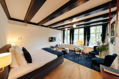 a bedroom with a bed and a living room at 1637: Historic Canal View Suites in Amsterdam