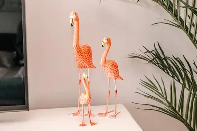three wooden flamingos on a table with a plant at Studio Maxime in Zandvoort