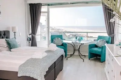 a bedroom with a bed and a table and chairs at Studio Maxime in Zandvoort