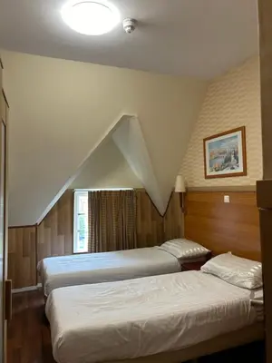 two beds in a room with a staircase at Hotel Isis in Amsterdam