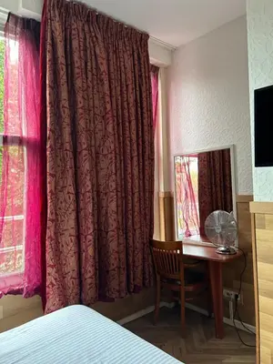 a bedroom with a bed and a desk and a mirror at Hotel Isis in Amsterdam