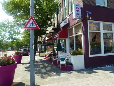 a pedestrian crossing sign on a pole on a city street at Hotel Isis in Amsterdam