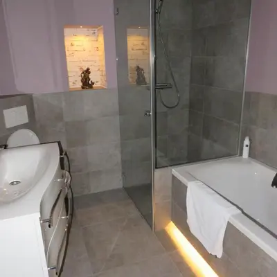 a bathroom with a shower and a tub and a sink at Villa Braas in Breukeleveen
