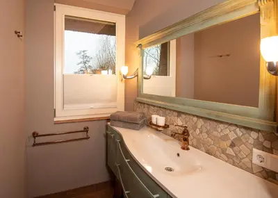 a bathroom with a sink and a mirror and a window at Villa Braas in Breukeleveen