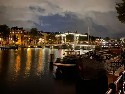 a city at night with boats in the water at Amstel Boutique Studio in Amsterdam