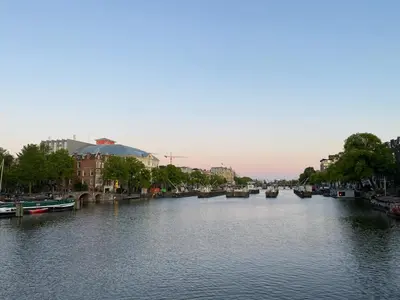 a river with boats on it in a city at Amstel Boutique Studio in Amsterdam