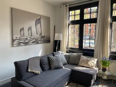 a living room with a blue couch and windows at Amstel Boutique Studio in Amsterdam