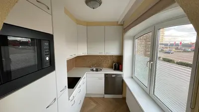 a small kitchen with a microwave and a window at Beach Apartments Seaview in Zandvoort
