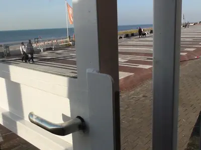 a boardwalk with people walking on the beach at Beach Apartments Seaview in Zandvoort