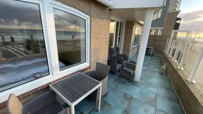 a balcony with a table and chairs on a house at Beach Apartments Seaview in Zandvoort