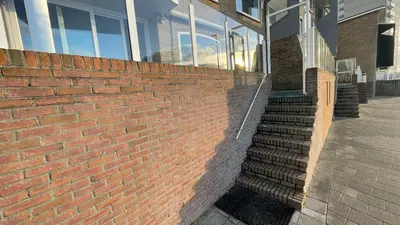 a brick wall with stairs in front of a building at Beach Apartments Seaview in Zandvoort