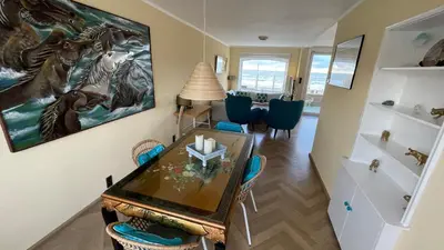 a dining room with a table and a painting on the wall at Beach Apartments Seaview in Zandvoort