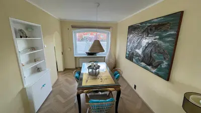 a dining room with a table and a painting on the wall at Beach Apartments Seaview in Zandvoort
