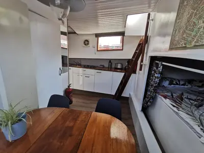 a dining room with a table and a kitchen at Waterloo square river vieuw houseboat in Amsterdam