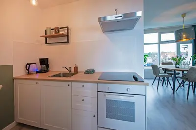 a kitchen with a sink and a stove top oven at Amsterdam Beach Apartment 90 in Zandvoort