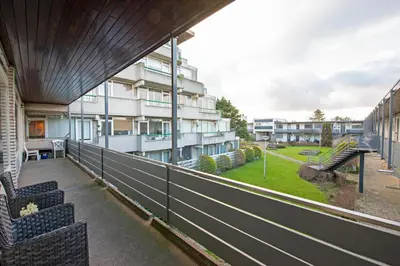 a balcony with two chairs and a building at Amsterdam Beach Apartment 90 in Zandvoort