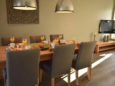 a dining room with a table with chairs and a television at Villa in Schoorldam with Garden in Schoorldam