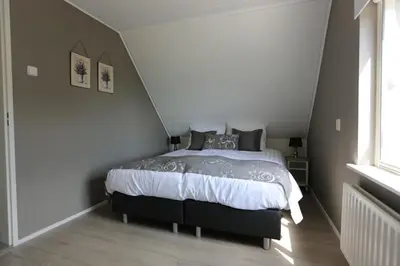 a bedroom with a large bed in a attic at Het Jaarsveldhof in Montfoort