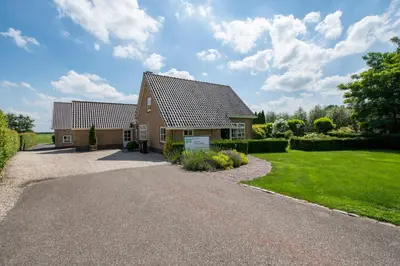 a house with a gravel driveway in front of it at Het Jaarsveldhof in Montfoort