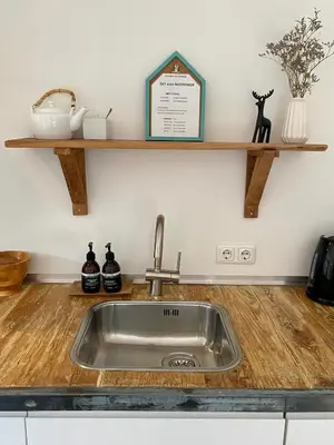 a kitchen counter with a sink and a shelf at ZILT sous in Noordwijk