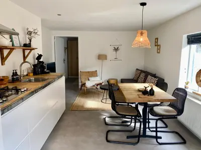a kitchen and living room with a wooden table and chairs at ZILT sous in Noordwijk