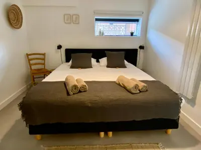 a bedroom with a large bed with two towels on it at ZILT sous in Noordwijk