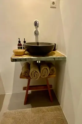 a bathroom with a sink and a shelf with towels at ZILT sous in Noordwijk