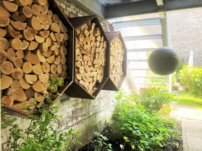 a bunch of fire wood hanging on a wall at 23 SouS in Amsterdam
