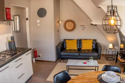 a living room with a couch and a table at Zeehuis Appartement & Studio in Zandvoort