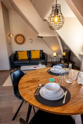 a dining room table with chairs and a couch at Zeehuis Appartement & Studio in Zandvoort