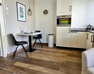 a kitchen with a table and two chairs and a table at Zeehuis Appartement & Studio in Zandvoort