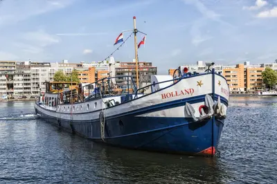 a blue and white boat sitting in the water at Mps Holland in Amsterdam
