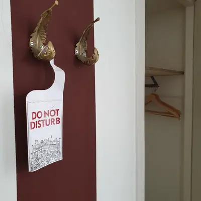 a do not disturb sign hanging on a wall at Sonnevanck Wijk aan Zee in Wijk aan Zee