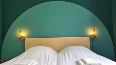 a bed with two towels and two lights on it at Sonnevanck Wijk aan Zee in Wijk aan Zee
