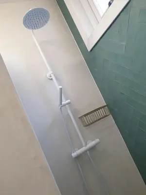 a bathroom with a toothbrush and a floor with a drain at Sonnevanck Wijk aan Zee in Wijk aan Zee