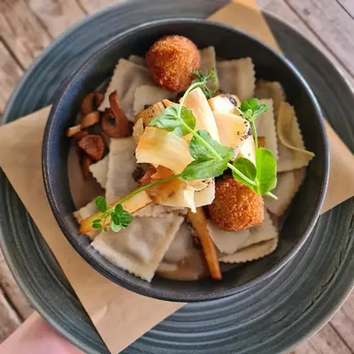 a bowl of food on a plate on a table at Sonnevanck Wijk aan Zee in Wijk aan Zee