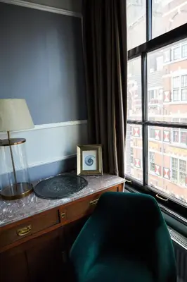 a room with a desk with a clock and a window at Redlightdistrict chinacitycentre partypalace in Amsterdam