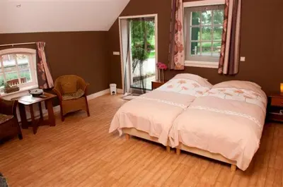 a bedroom with a bed and a table and a desk at Apud nos Domi in Polsbroek
