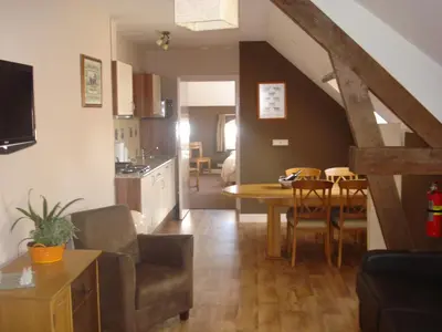 a kitchen and a living room with a table and chairs at Apud nos Domi in Polsbroek