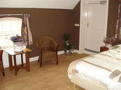 a bedroom with a bed and a table and a chair at Apud nos Domi in Polsbroek