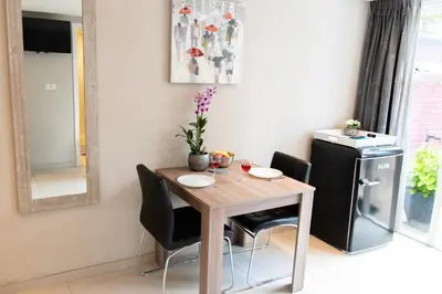 a dining room table with chairs and a small refrigerator at Studio Excellent 21 in Soesterberg