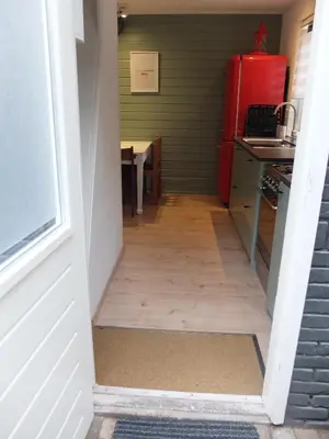 a hallway leading into a kitchen with a red refrigerator at Pelt 35 in Bergen