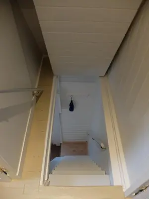a hallway with stairs leading up to a white room at Pelt 35 in Bergen