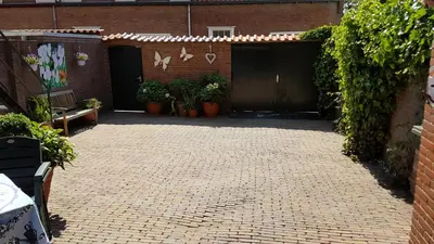 a brick courtyard with a garage with plants at Appartement in Zandvoort in Zandvoort