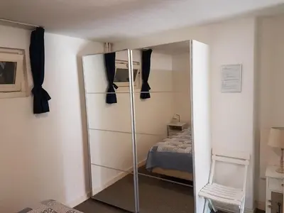 a bedroom with a glass closet and a bed at Appartement in Zandvoort in Zandvoort